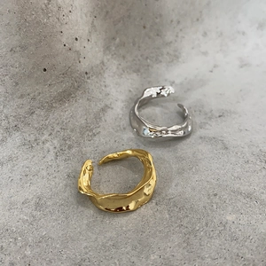 Detail of irregular liquid metal rings in gold and silver with textured finish