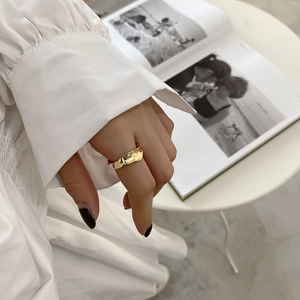 Macro detail of gold irregular wavy ring with hammered texture and polished metal surface
