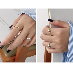 Close-up of gold and silver irregular wavy rings with a polished metal finish