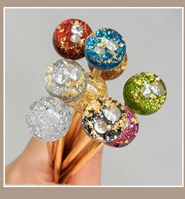 Detail of colorful resin hair pins with gold foil and rhinestones in rose gold metal