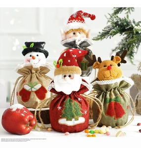 Detail of Christmas drawstring gift bags featuring festive 3D dolls and lace trim