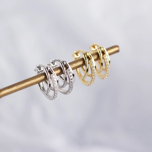 Detailed close-up of double-hoop earrings in gold and silver with pave-set cubic zirconia