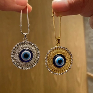 Detail of gold and silver Evil Eye safety pin brooches with sparkling crystals