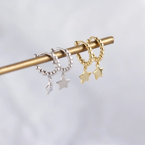 Detail of S925 silver beaded hoop earrings with star pendants in gold and silver