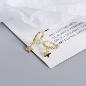 Macro view of gold S925 sterling silver hoop earrings with star pendants and beads