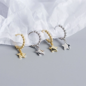 Detailed macro shot of S925 sterling silver star pendant hoop earrings in gold and silver