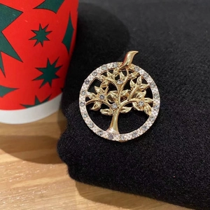 Detailed close-up of a gold tree of life brooch with sparkling crystal rhinestones