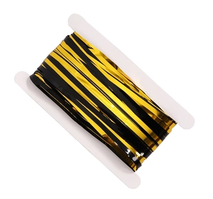 Gros plan du rideau à franges métalliques rayé noir et or sur une bobine en plastique