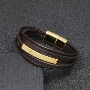 Close-up of brown leather multi-layer bracelet with gold metal bars and magnetic clasp