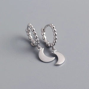 Vista macro di orecchini a cerchio in argento sterling S925 con perline e ciondoli a luna