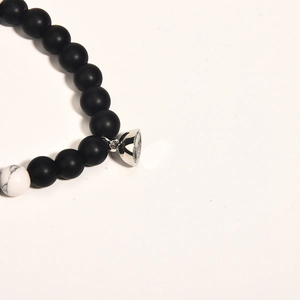 Detail of beaded couple bracelet with black matte beads and heart magnetic clasp