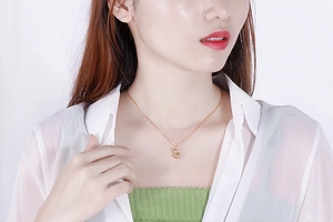 Close-up of 18K gold plated interlocking circles pendant necklace on model's neck
