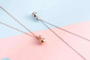 Detailed view of silver and rose gold gourd pendants on delicate link chains