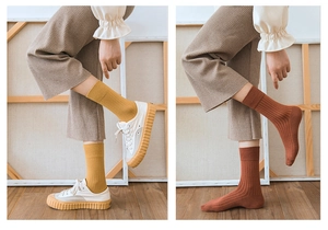 Detailed texture of yellow and brown ribbed knit cotton crew socks in a lifestyle setting