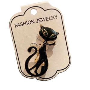 Vintage style black enamel cat brooch with green gem eyes and gold plating on white card