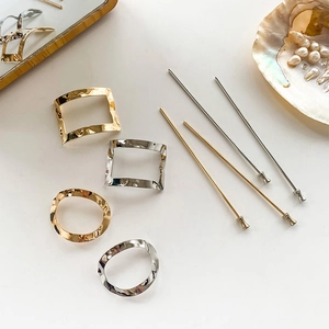 Elegant gold and silver metal geometric hair pins and clips set on a minimalist background