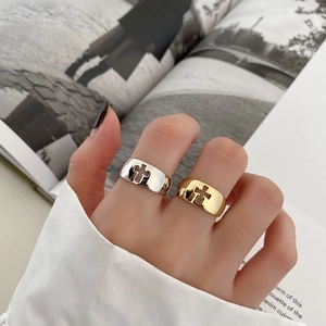 Close-up of wide S925 sterling silver rings with hollow cross design on fashion magazine