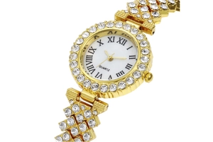 Close-up of gold women's watch with rhinestones, Roman numerals and quartz dial
