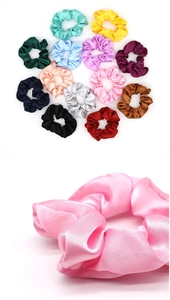 Detail of assorted colorful satin scrunchies featuring high-gloss fabric texture