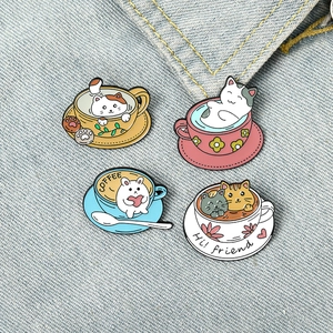 Detailed view of four colorful cat and bunny enamel pins on blue denim fabric