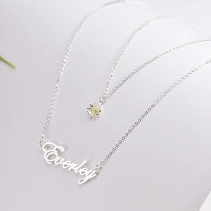Macro view of silver double-layer necklace with flower charm and Everley nameplate