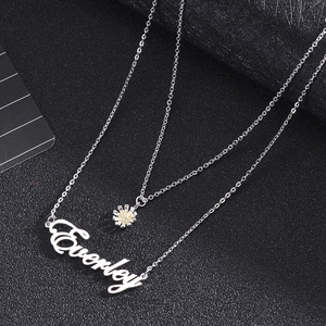 Detail of silver double layer necklace featuring a daisy charm and Everley name pendant