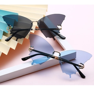 Detailed view of rimless butterfly sunglasses with gold nose bridge and rivet accents