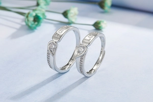 Detail of silver couple rings with Forever Love engraving forming a heart shape