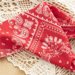 Detail of red paisley headband on vintage lace cloth with soft focus on fabric texture