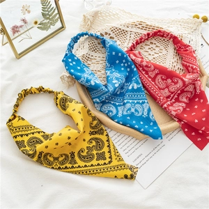 Flat lay of colorful paisley elastic headbands in yellow, blue and red on vintage lace