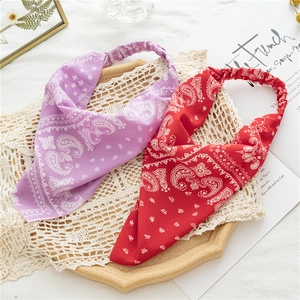 Macro shot of purple and red paisley headbands on a rustic wooden tray with lace detail