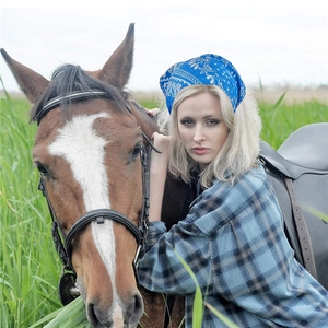 Blue paisley bandana headband for women worn by a model in a scenic outdoor setting