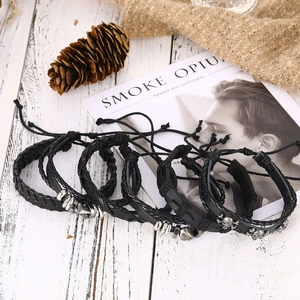 Macro view of black leather punk skull bracelets set with silver beads and woven charms