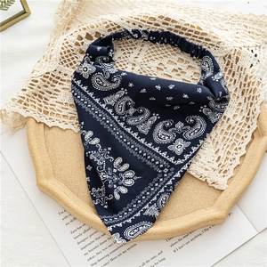 Detail of navy blue paisley elastic headband with silky texture on an elegant vintage tray