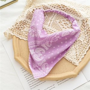 Detail of light purple paisley headband with elastic band on a wooden tray with lace