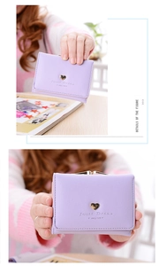 Close-up of lavender purple tri-fold wallet featuring gold heart and vintage clasp closure