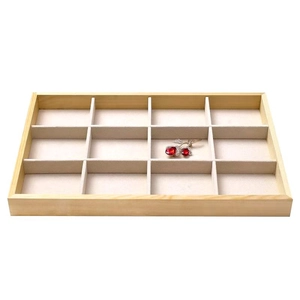 Macro shot of 12-slot wooden jewelry tray with beige velvet lining for rings and studs