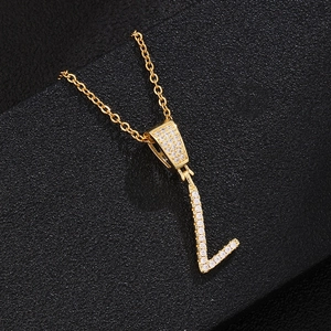 Macro shot of letter L pendant necklace with cubic zirconia paving on golden chain