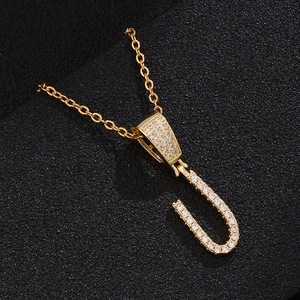 Macro view of gold-plated letter U pendant necklace with sparkling cubic zirconia inlay