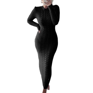 Detailed cable knit texture and slim fit design of a black long-sleeve sweater dress