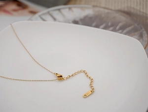 Close-up of golden stainless steel chain with lobster clasp and K18 hallmark tag