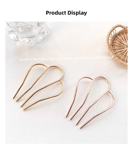 Close-up of gold and rose gold U-shaped metal hair forks with minimalist hollow design
