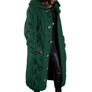Detail view of dark green cable knit cardigan sweater with chunky texture and large buttons