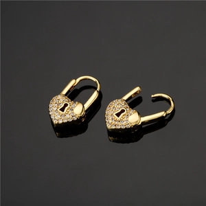 Orecchini a lucchetto a cuore dorati con cristalli micro-pave su superficie scura