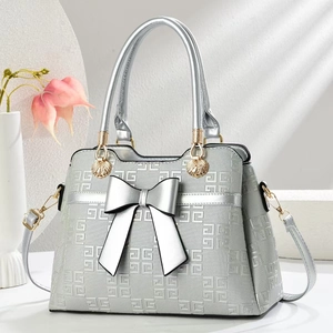 Silver bow handbag with geometric embossed texture and gold shell hardware for women