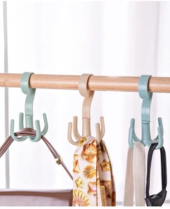 Close-up of rotatable four-claw hanger in mint green for organizing belts and bags