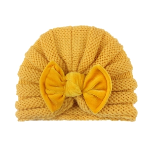 Bright yellow baby turban hat with a large velvet bow on a clean white background