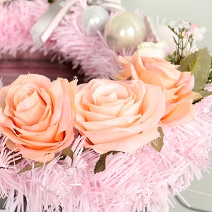 Pink Christmas wreath featuring artificial roses, decorative balls and soft fringe trim