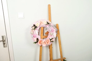 Detail of pink faux rose wreath with plush texture and Happy Day printed ribbon decoration