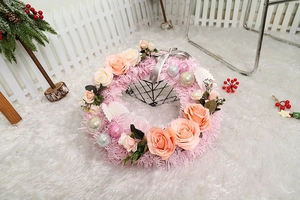 Macro detail of plush pink Christmas wreath with roses, ornaments and silk ribbon